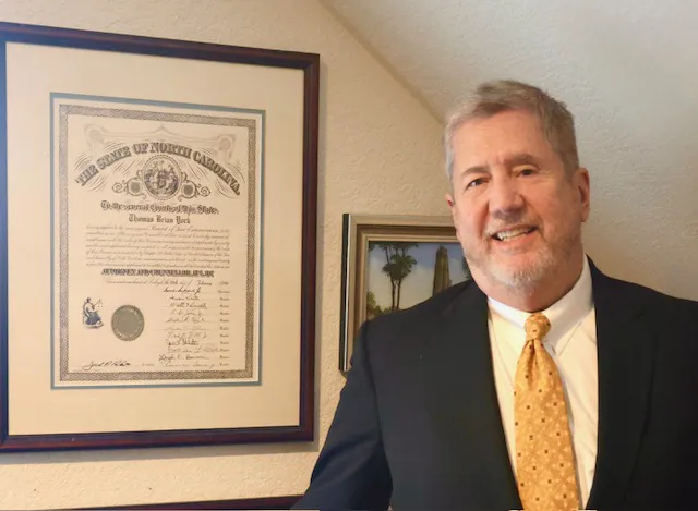 Thomas York standing with framed license