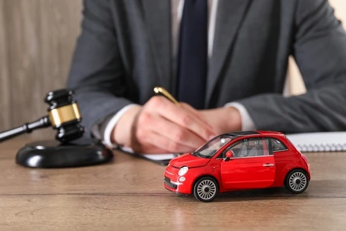 North Carolina car accident lawyer at desk with toy car