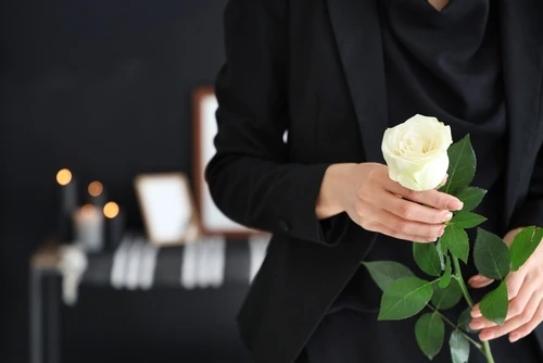 woman with rose at funeral who needs a North Carolina wrongful death lawyer