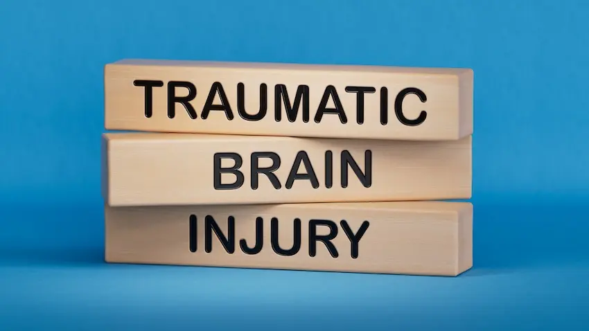 Stacked wooden blocks spelling traumatic brain injury on a blue background that highlight a serious head trauma medical condition at NC Injury Law in North Carolina.