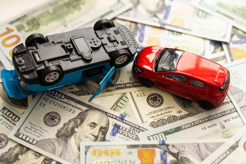 Concept of car accident compensation in North Carolina shown with two model cars and money